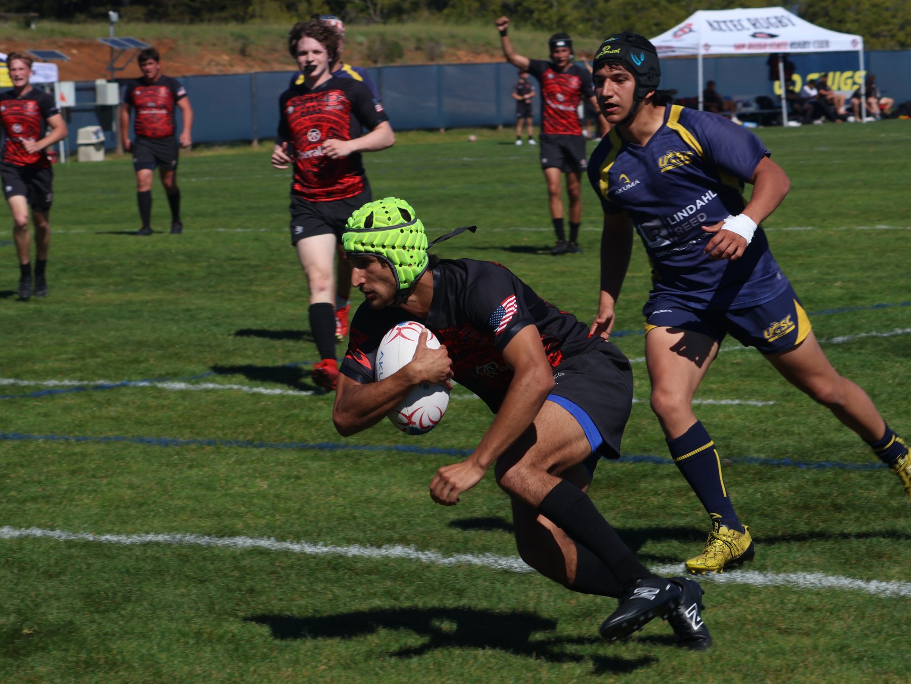 Rugby match action with a ball carrier moving past an opponent